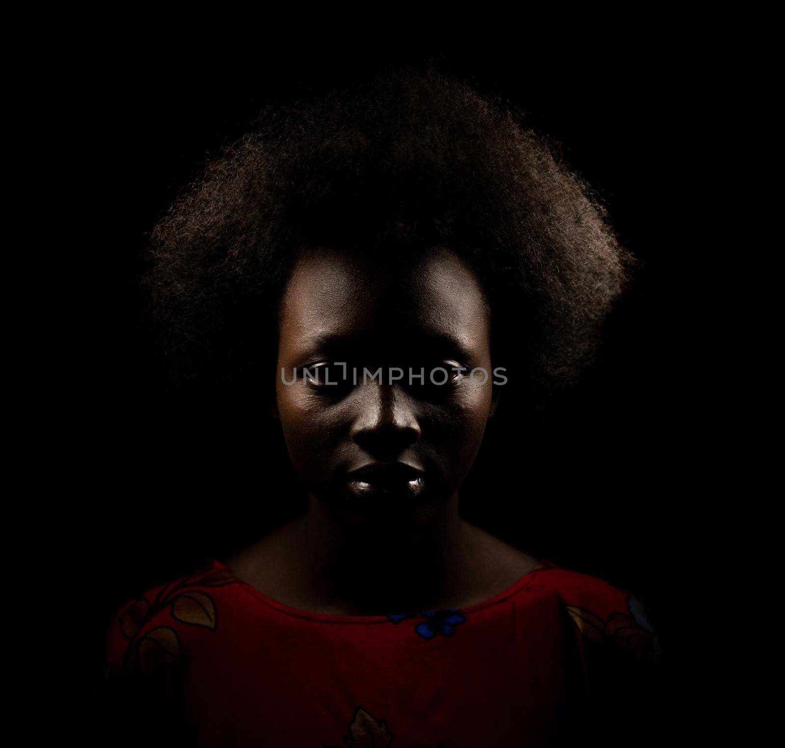 Dark portrait of young black woman in studio