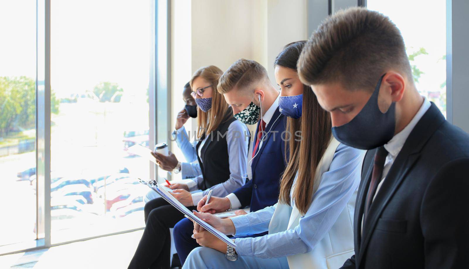 Stressful business people waiting for job interview with face mask, social distancing quarantine during COVID19 affect