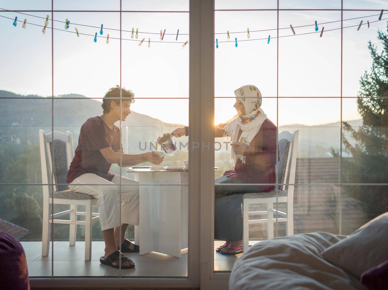 Mother and son enjoying drinking tea on the balcony