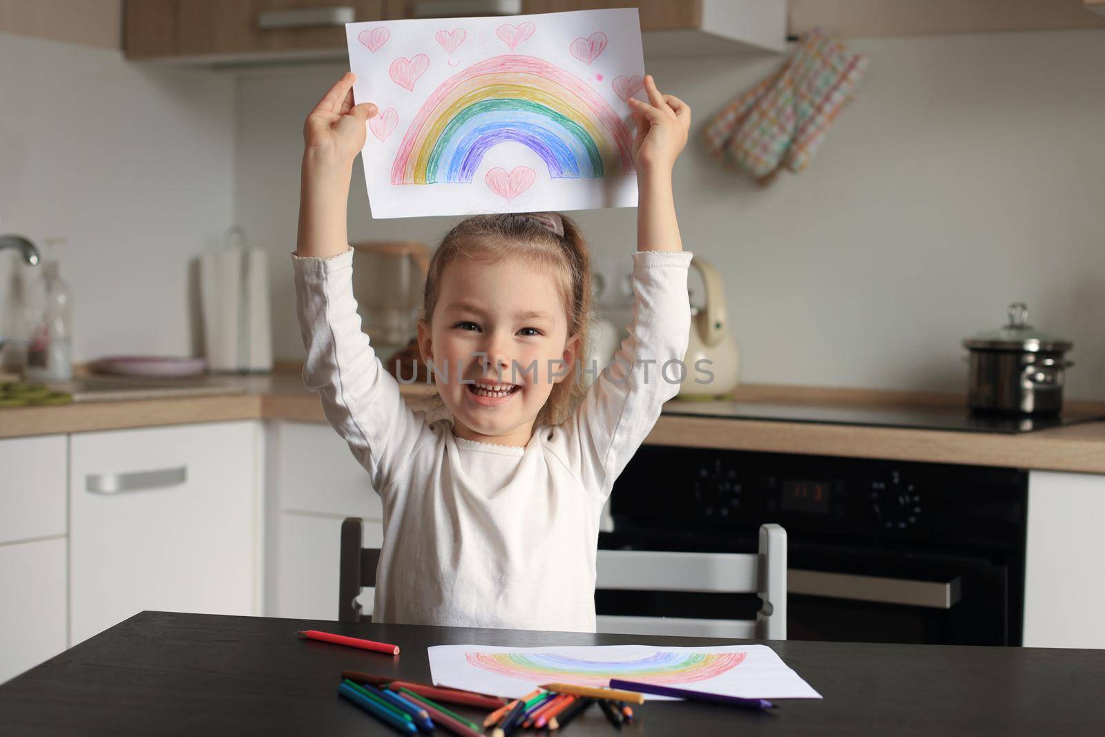 Girl painting rainbow at home, a symbol of UK National Health Service (NHS). Thanks to the doctors for their work. Stay at home Social media campaign. by tsyhun