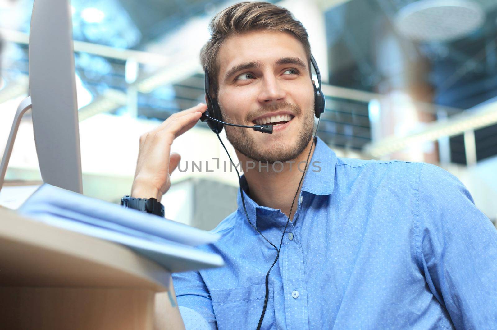 Smiling friendly handsome young male call centre operator. by tsyhun