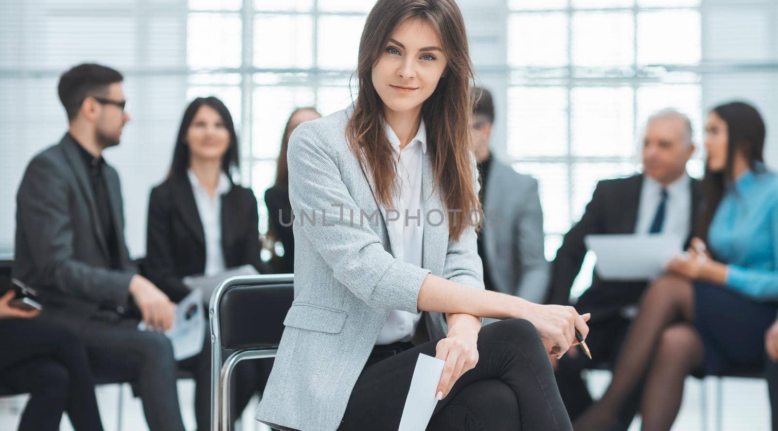 confident young business woman sitting in office by SmartPhotoLab