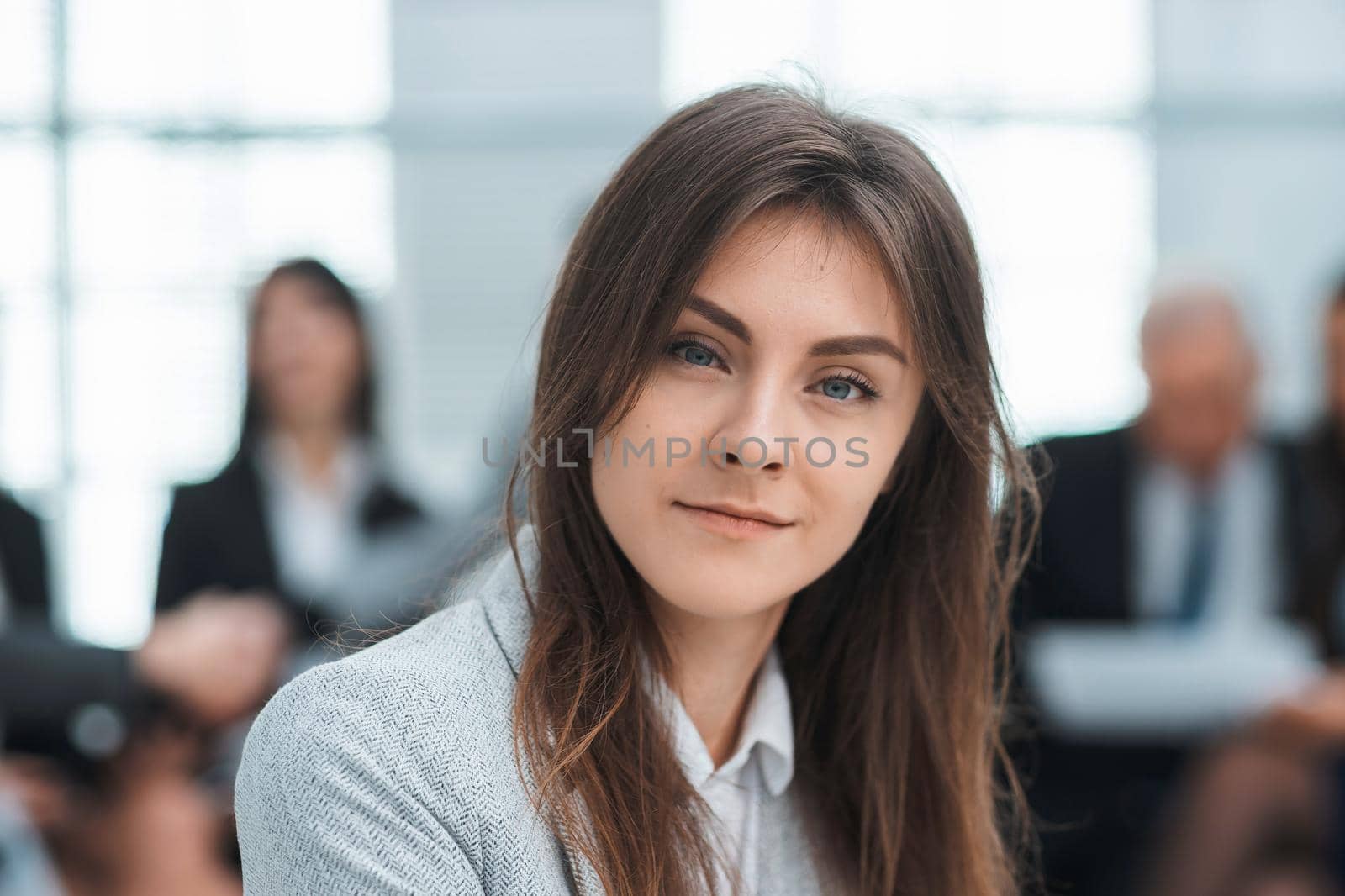 confident young business woman sitting in office by SmartPhotoLab
