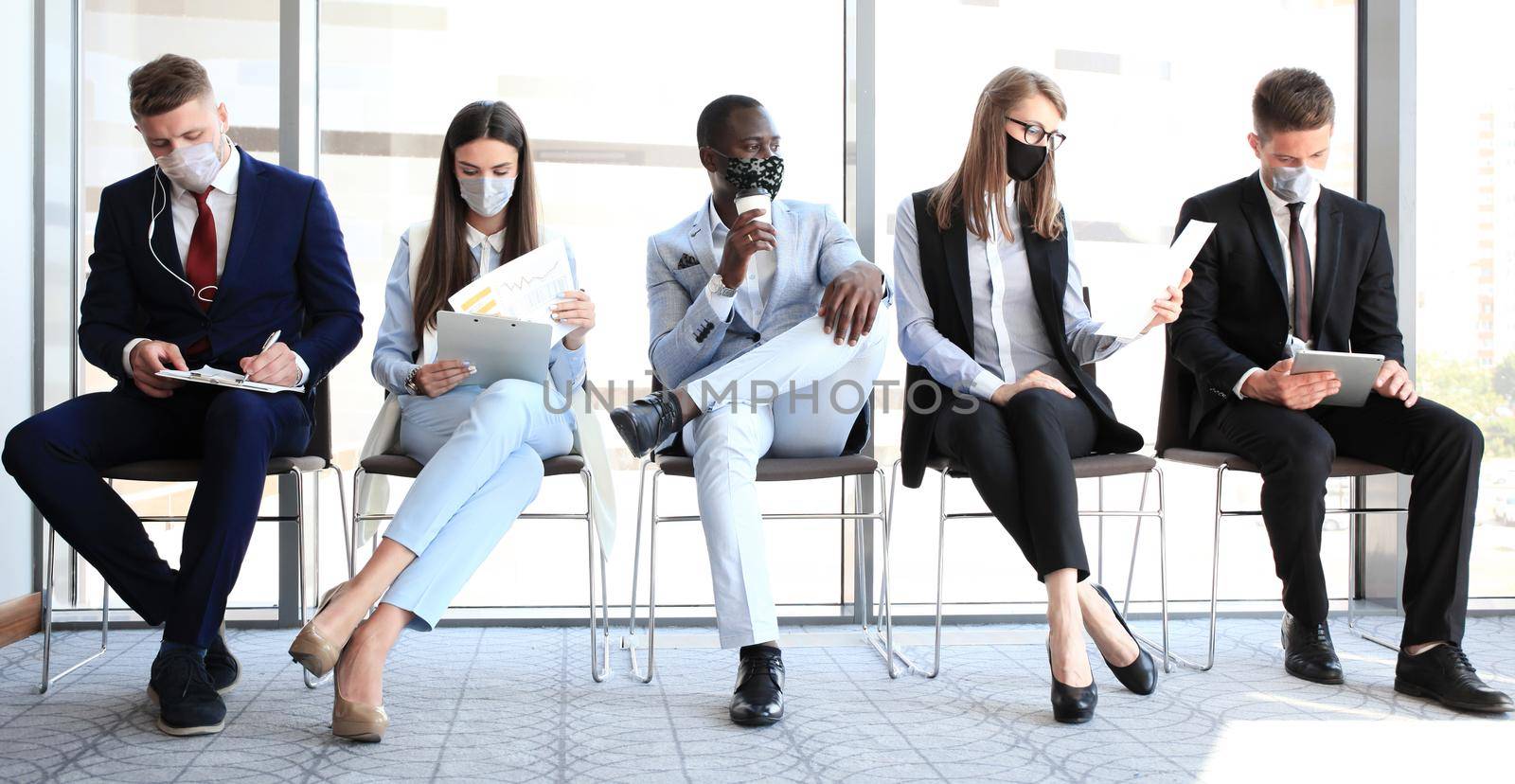 Stressful business people waiting for job interview with face mask, social distancing quarantine during COVID19 affect by tsyhun
