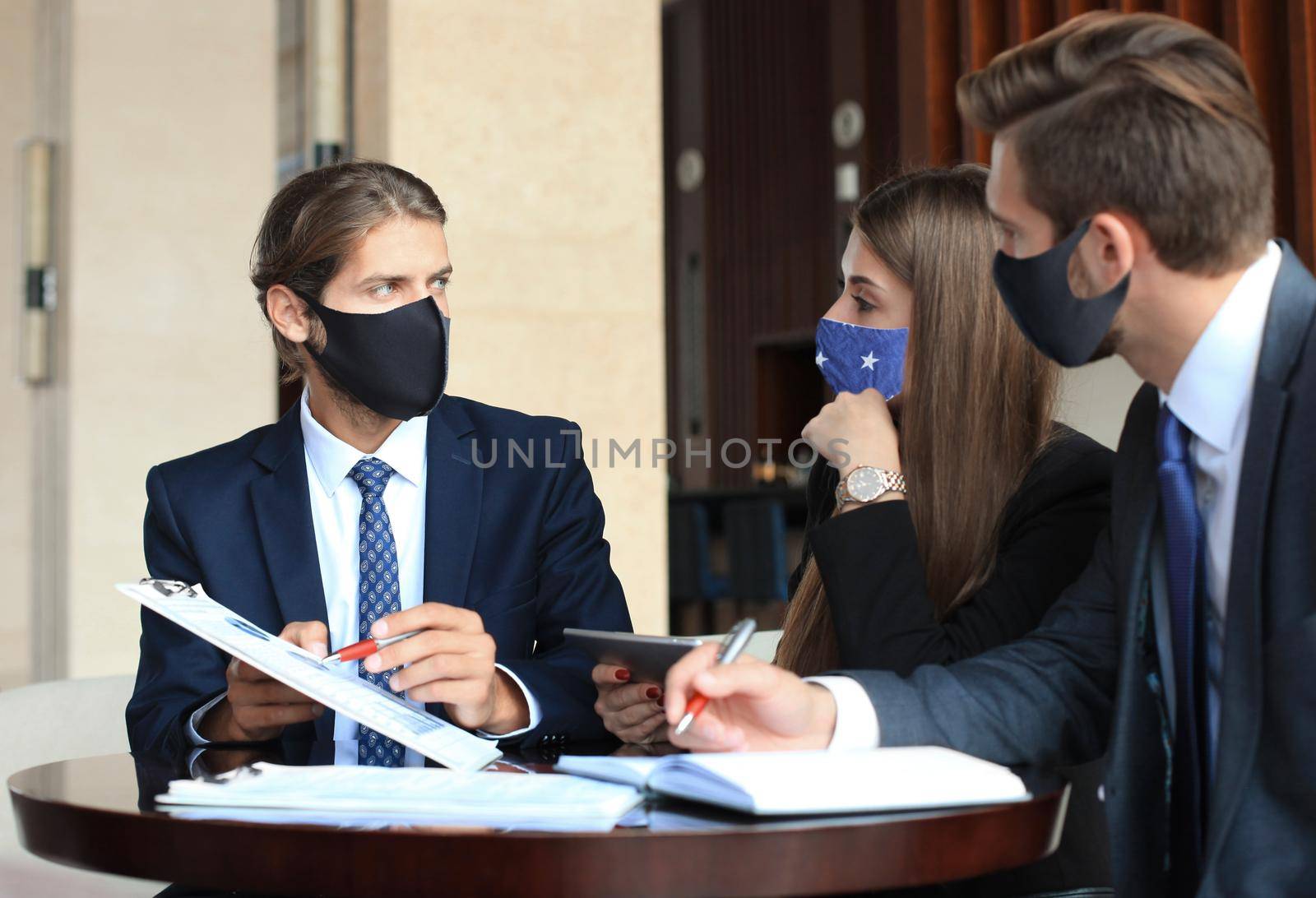 Business people in protective masks working on new project at modern office