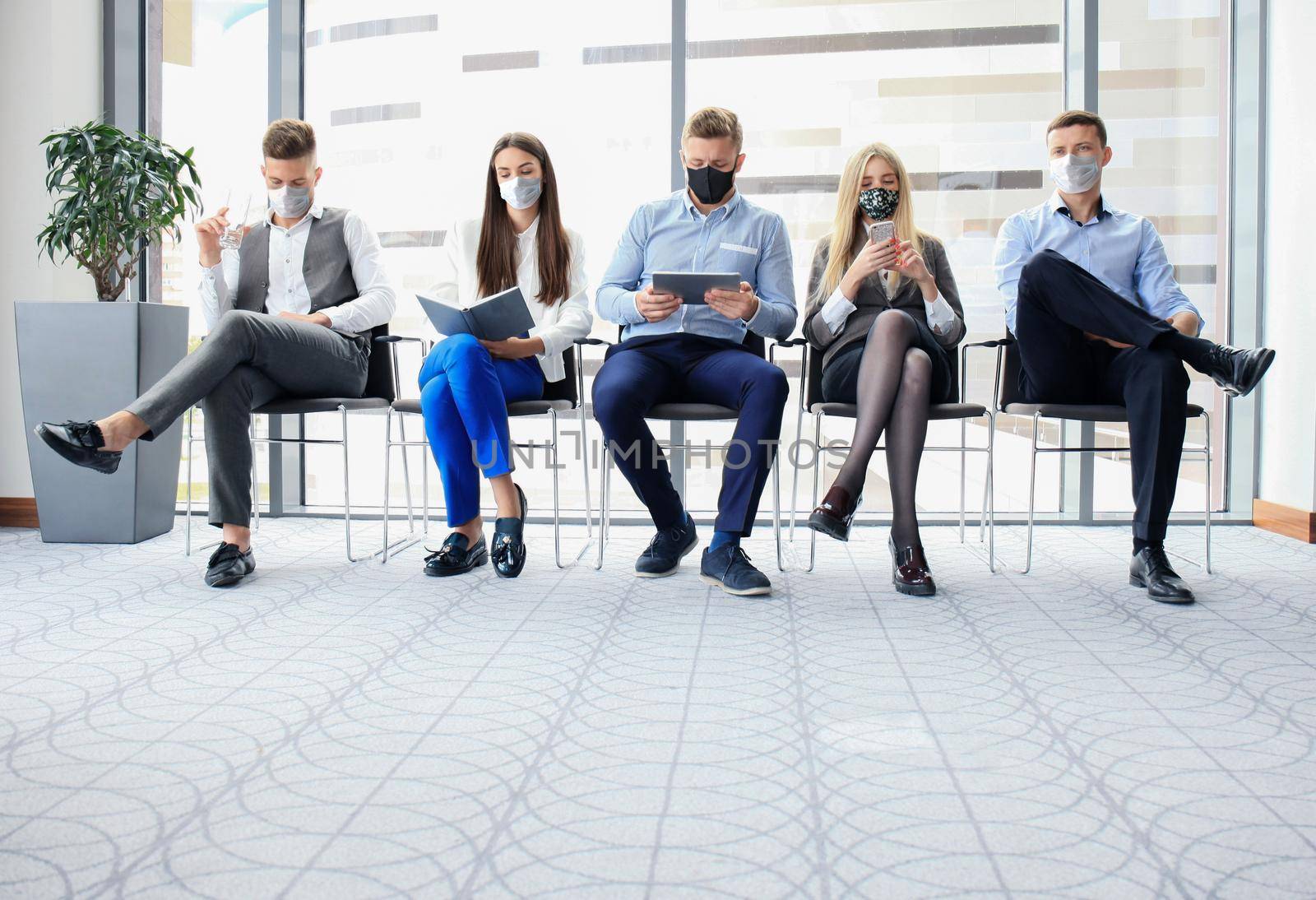 Stressful business people waiting for job interview with face mask, social distancing quarantine during COVID19 affect. by tsyhun