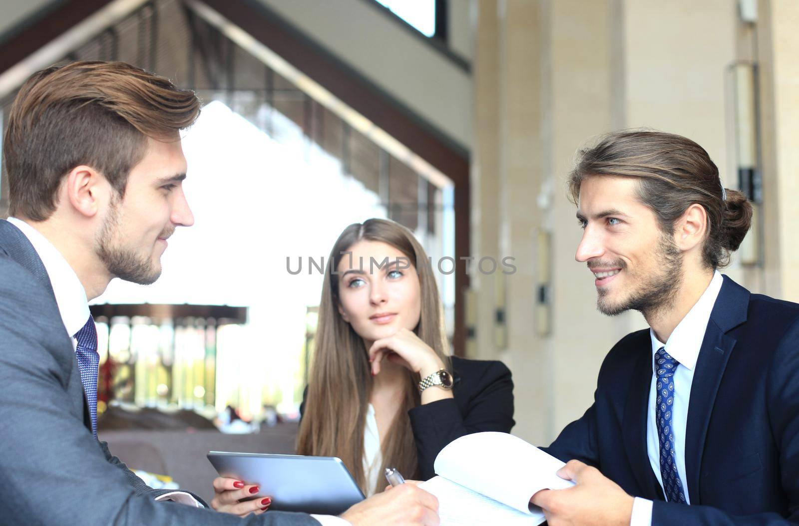 Businessman smiling happily as his business partner finally signing important contract.