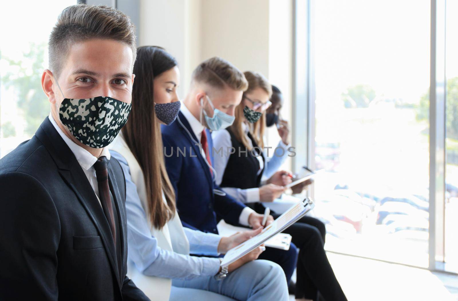 Stressful business people waiting for job interview with face mask, social distancing quarantine during COVID19 affect by tsyhun