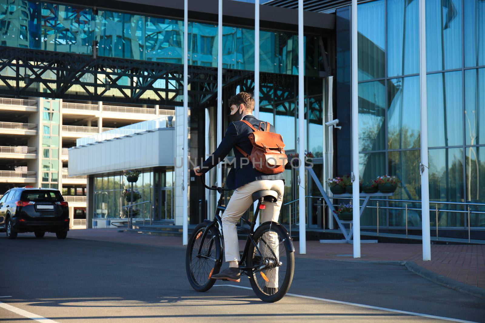 Handsome man in protective mask riding a bicycle to find job