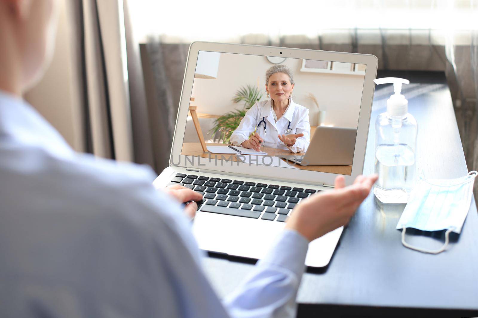 Young woman making video call with her doctor during self isolation and quarantine. Online consultation. Patient in video conferencing with general practitioner on digital tablet. Coronavirus