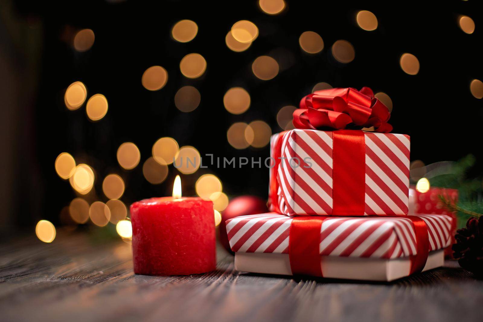 candle and gift boxes on the background of Christmas lights. photo with a copy-space.