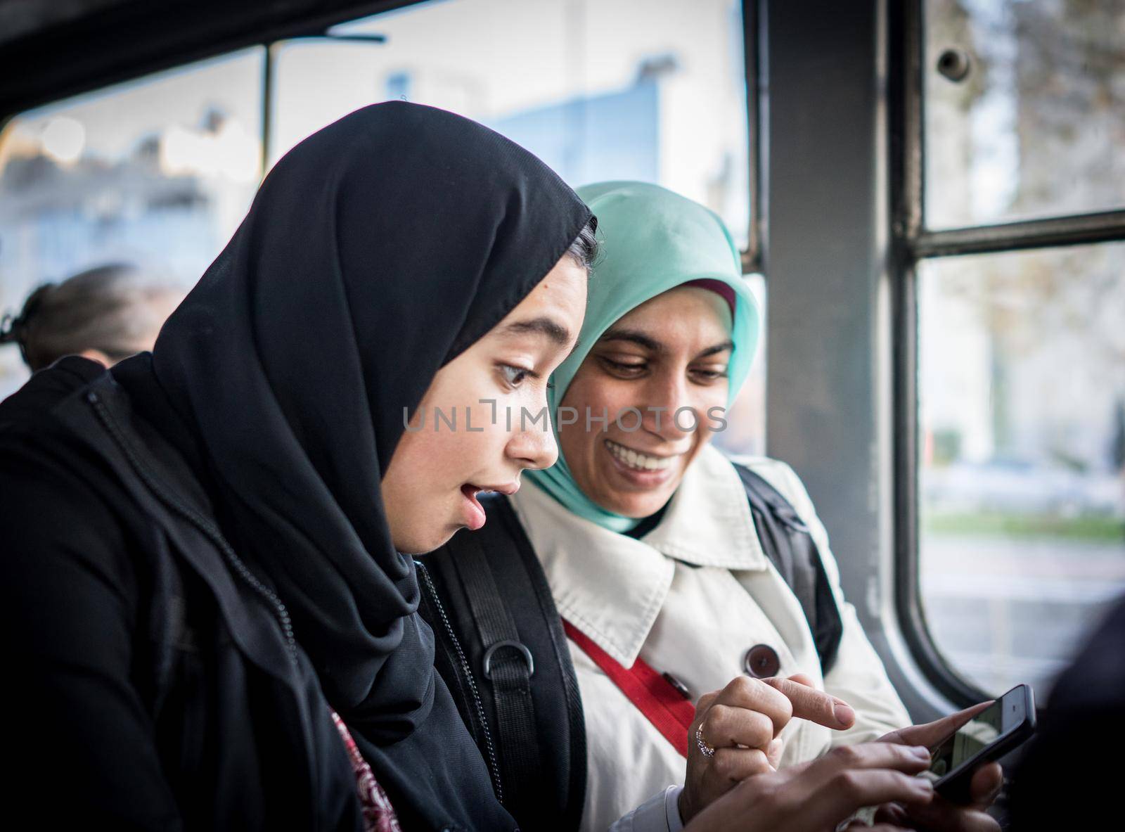 Mother and daughter riding public transport in the city