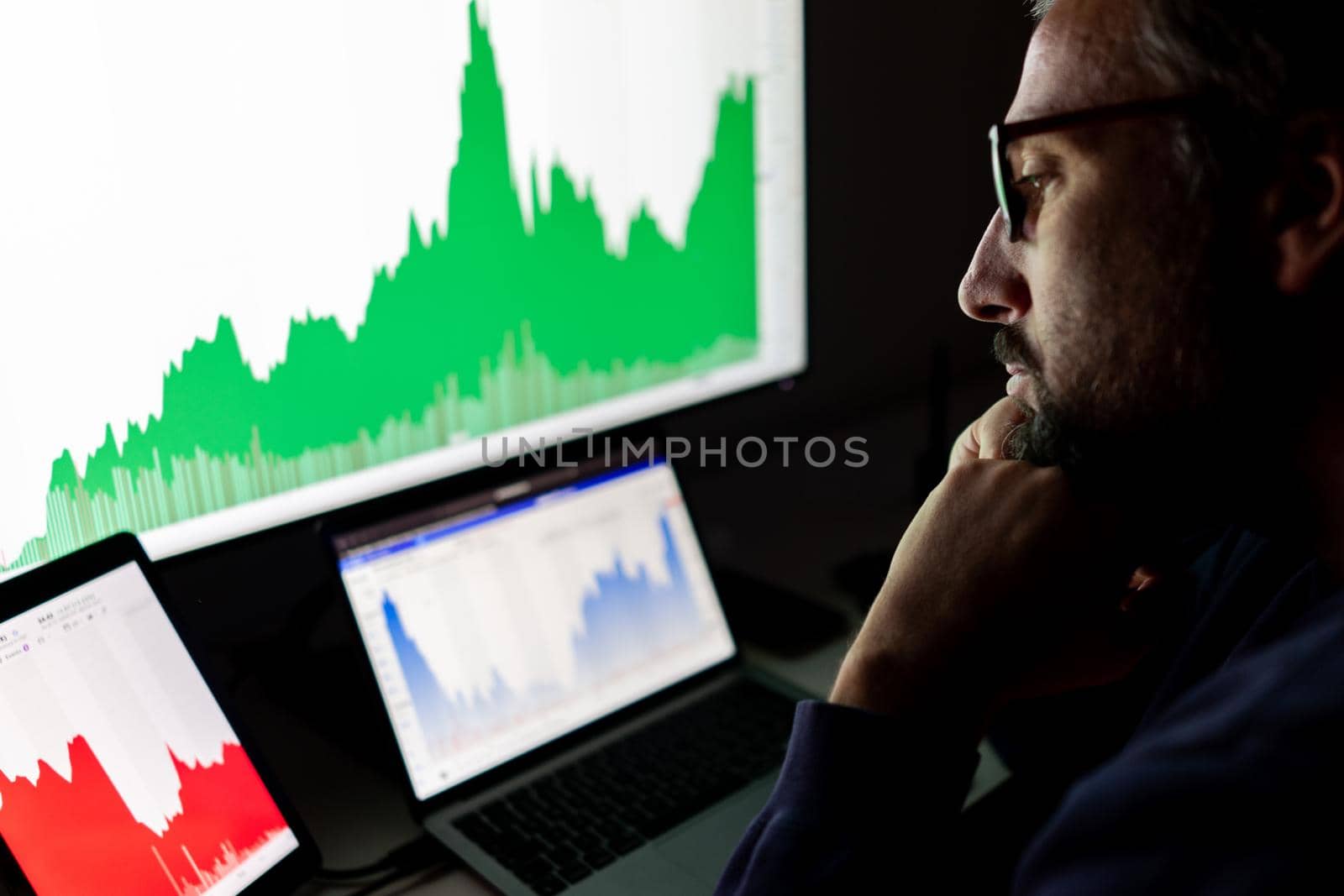 Crypto trader investor analyst looking at screen analyzing financial graph data on pc monitor, online stock exchange market ,over shoulder view.