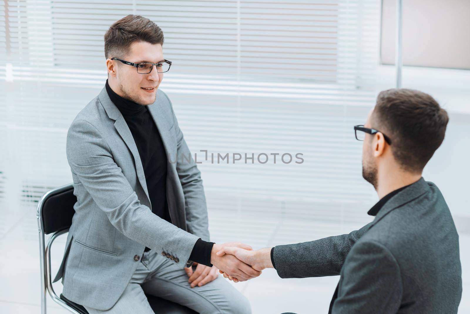 serious business colleagues shaking hands with each other. by SmartPhotoLab