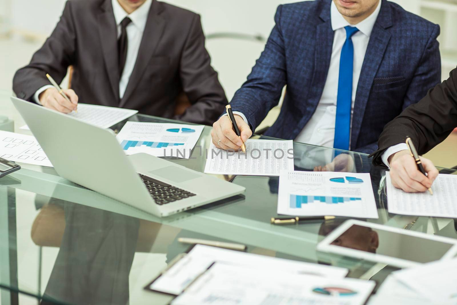close-up of a business team conducting analysis of marketing reports at the workplace in the office.