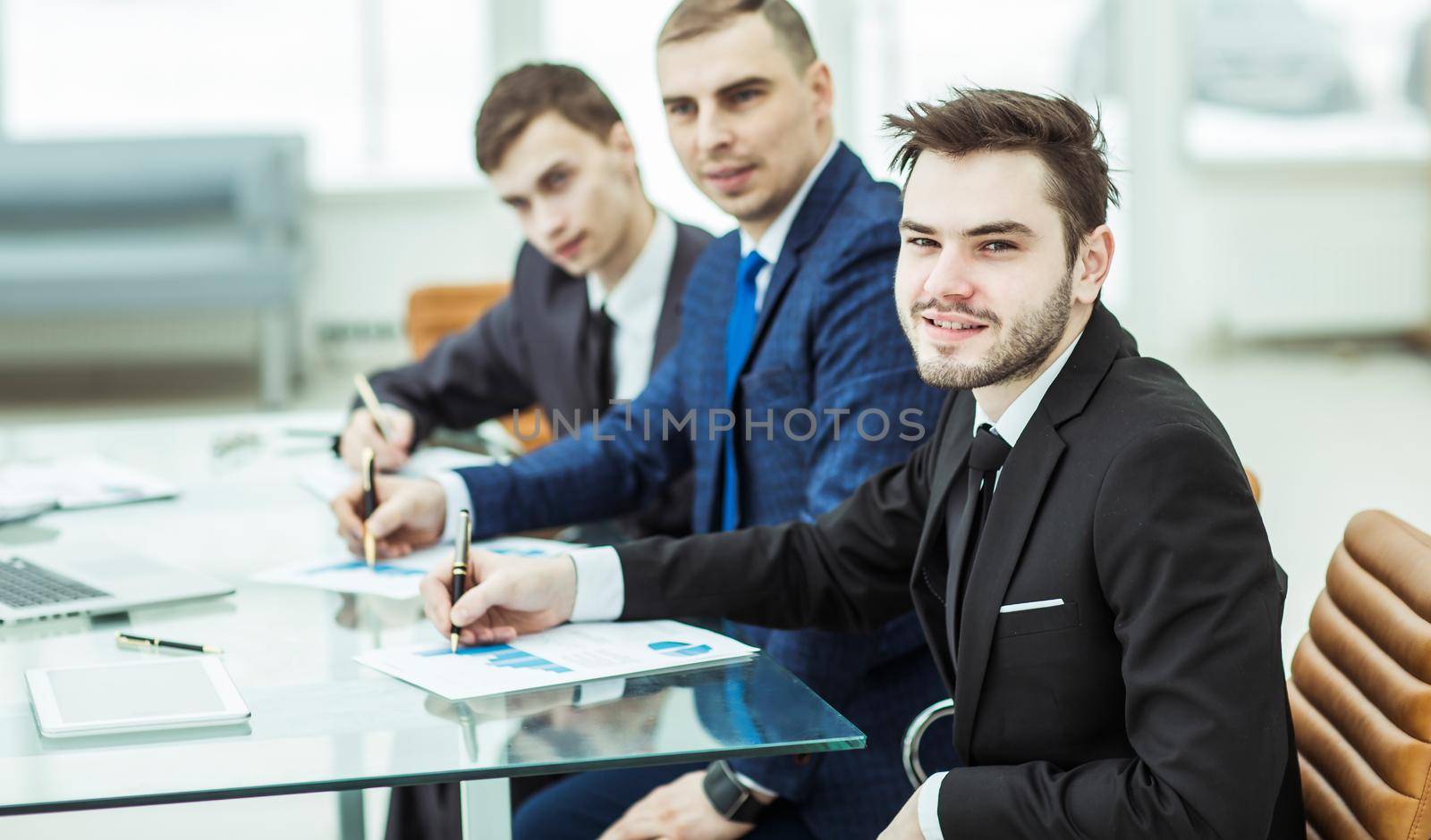 Manager Finance and business team are working with financial charts at his Desk in the office.the photo has a empty space for your text
