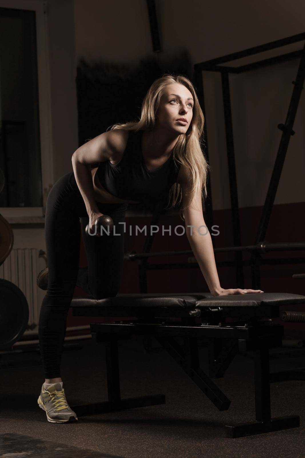 Young modern business woman at a fitness lesson in a modern fitness club.photo on a dark background