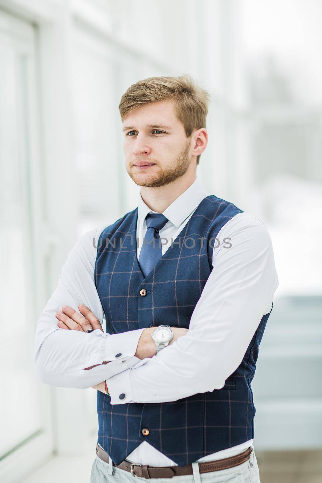 thoughtful beginner businessman standing near window with hands clasped in front of him.the photo has a empty space for your text