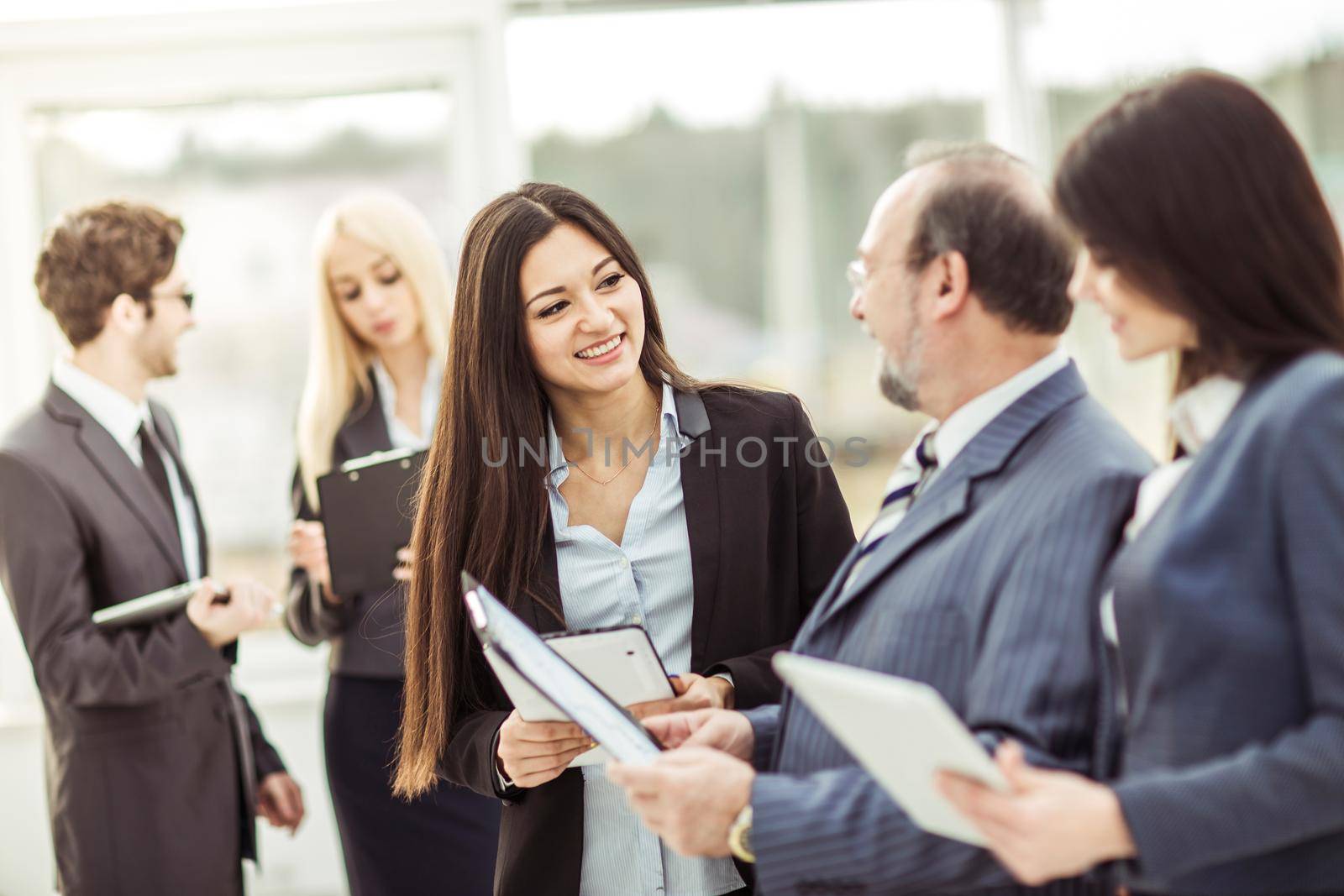 businessman and members of the business team discussing business documents standing in the lobby of the modern office.