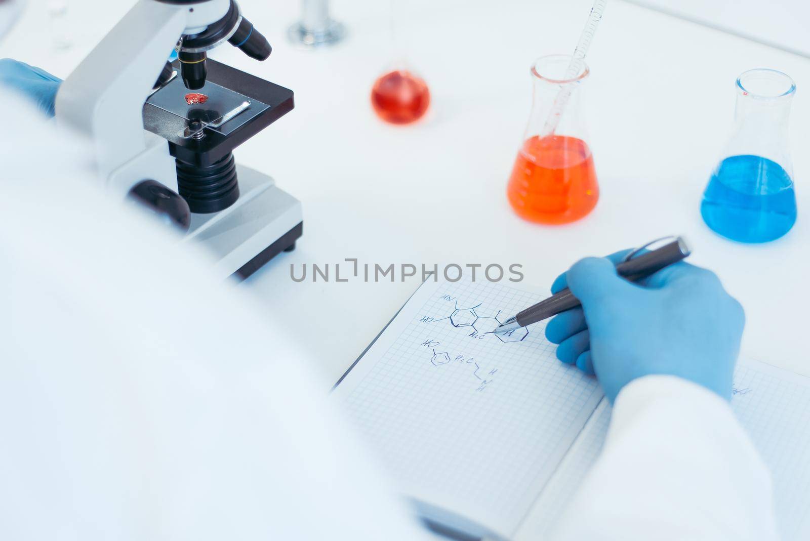 close up. scientist looking at a drop of blood through a microscope. by SmartPhotoLab
