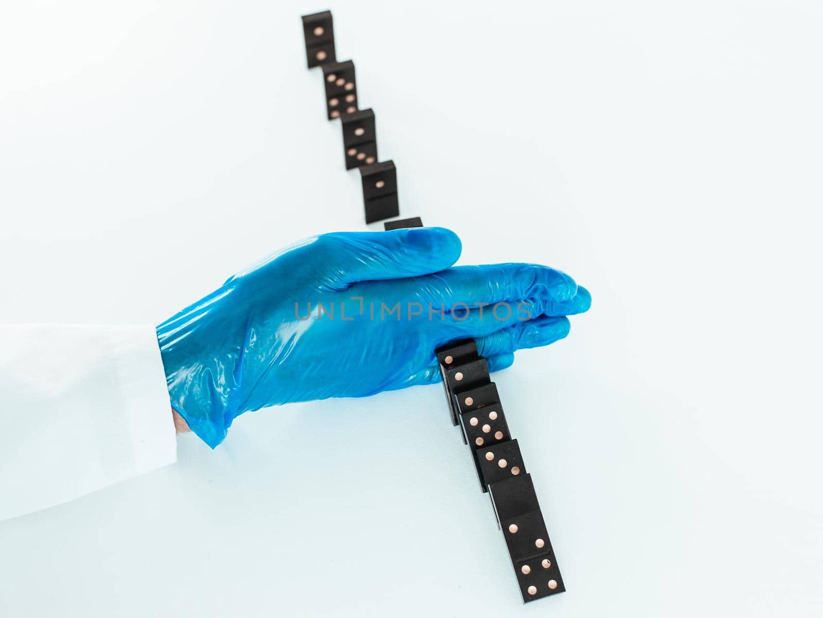 close up. doctor wearing protective gloves, placing dominoes . concept of health. by SmartPhotoLab
