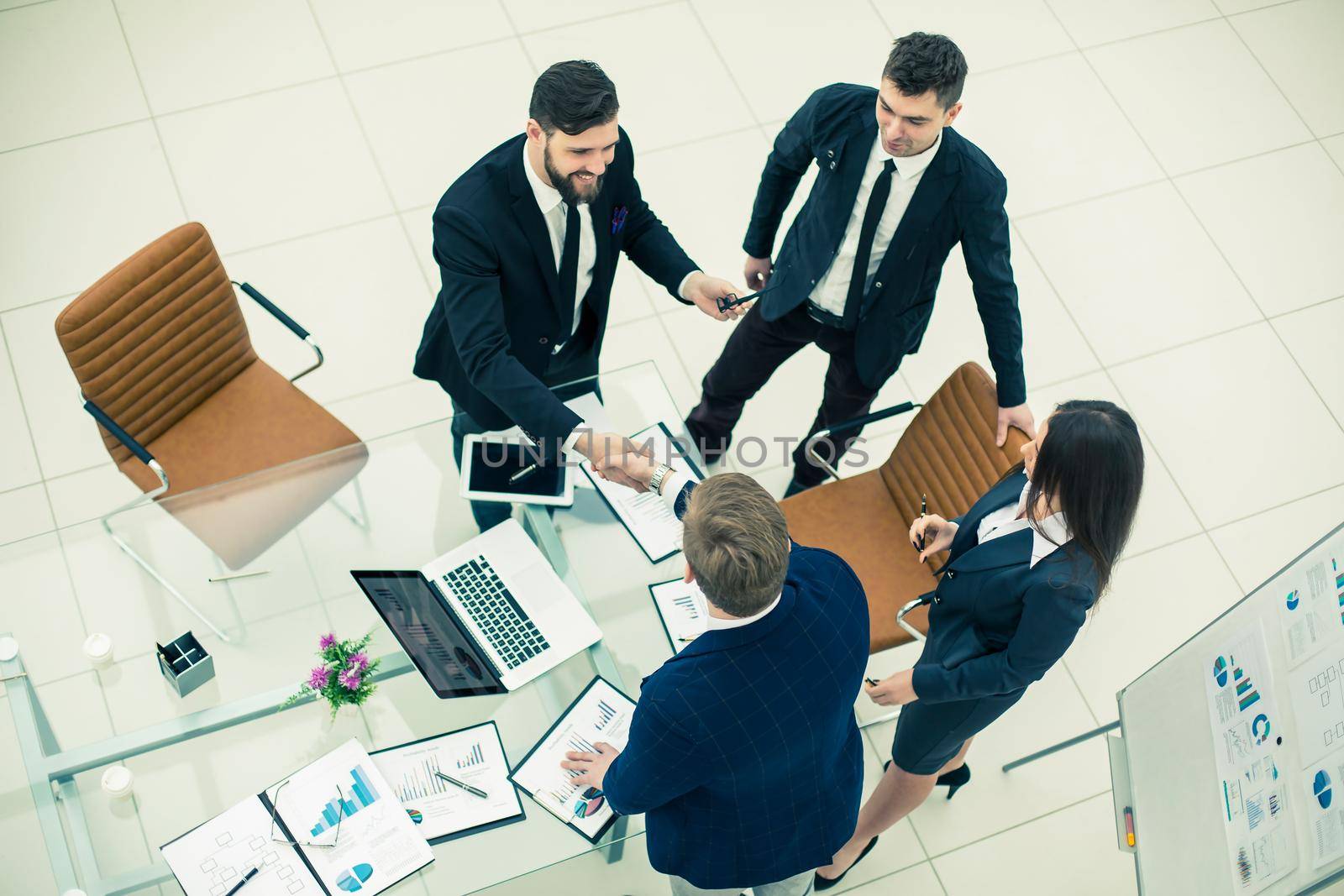 top view - handshake of business partners before the presentation of a new project in a modern office