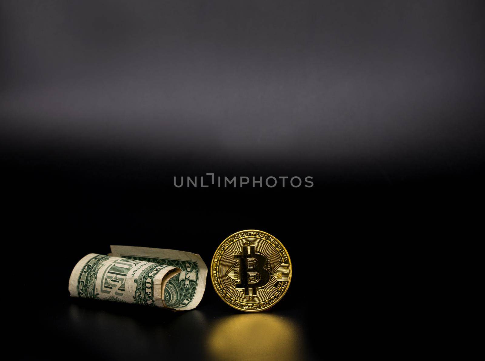 Gold Bitcoin and Dollar banknotes   on black background.