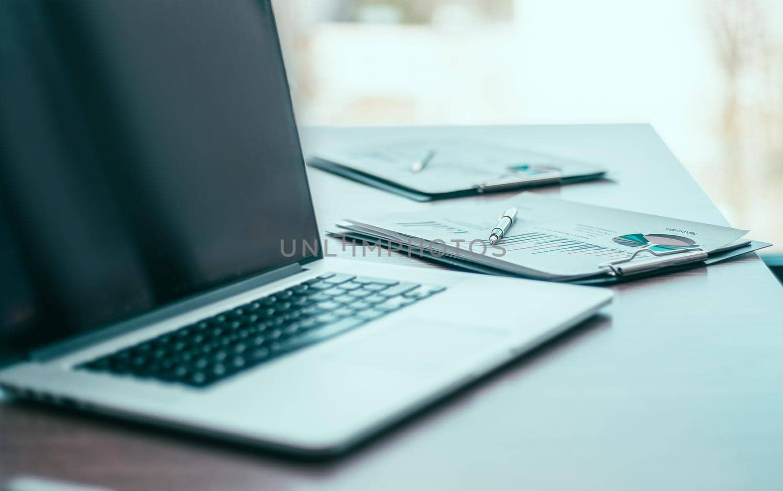 close up. a laptop computer and financial graph on the desktop. photo with a copy-space.