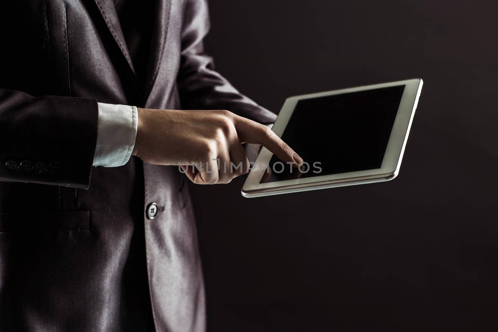 businessman finger presses on screen digital tablet.photo on a black background and has space for your text.