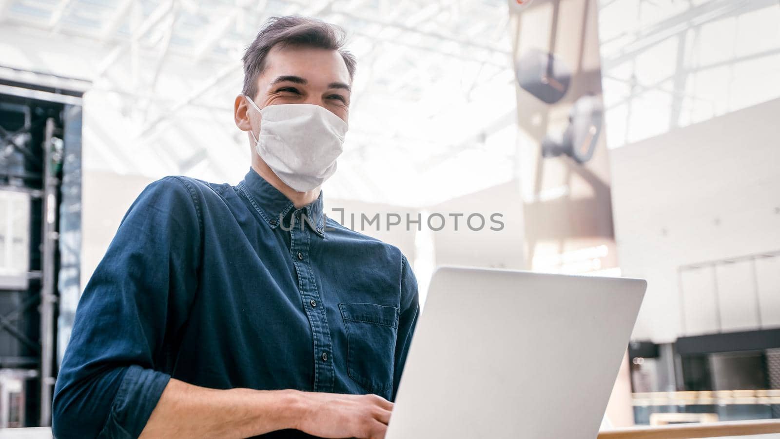 young blogger in protective mask looking through the window . pandemic in the city