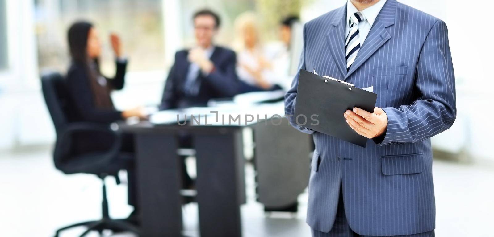 torso of a businessman with documents at office background by SmartPhotoLab
