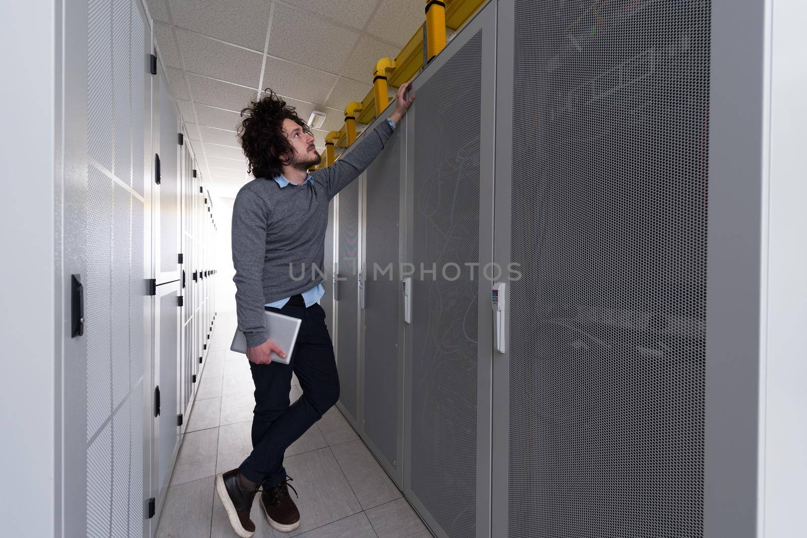 Male IT engineer working on a tablet computer in server room at modern data center