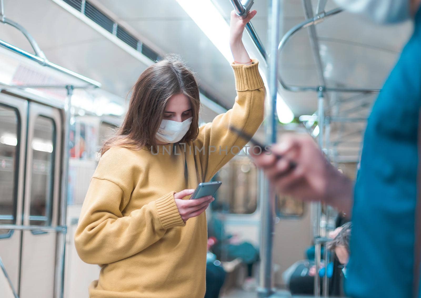 people with smartphones standing in a subway car. coronavirus in the city