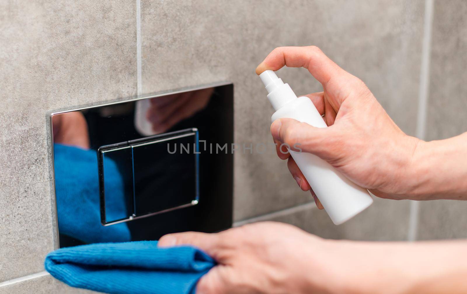 close up. employee spraying an antibacterial spray on the switch. photo with a copy-space.