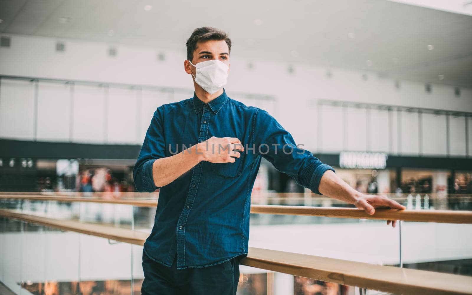 serious young man in a protective mask looking at the deserted city. by SmartPhotoLab