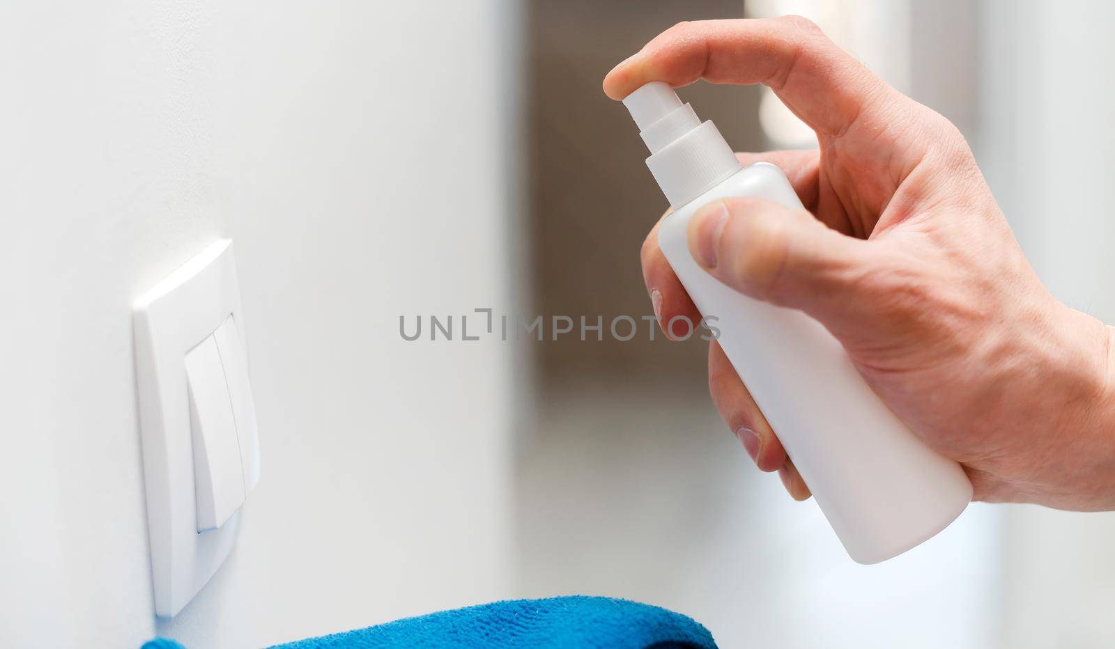 close up. employee treating the wall switch with an antibacterial spray. photo with a copy-space.