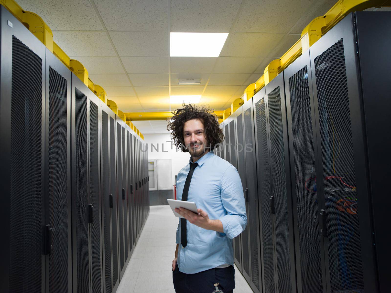 Male IT engineer working on a tablet computer in server room at modern data center