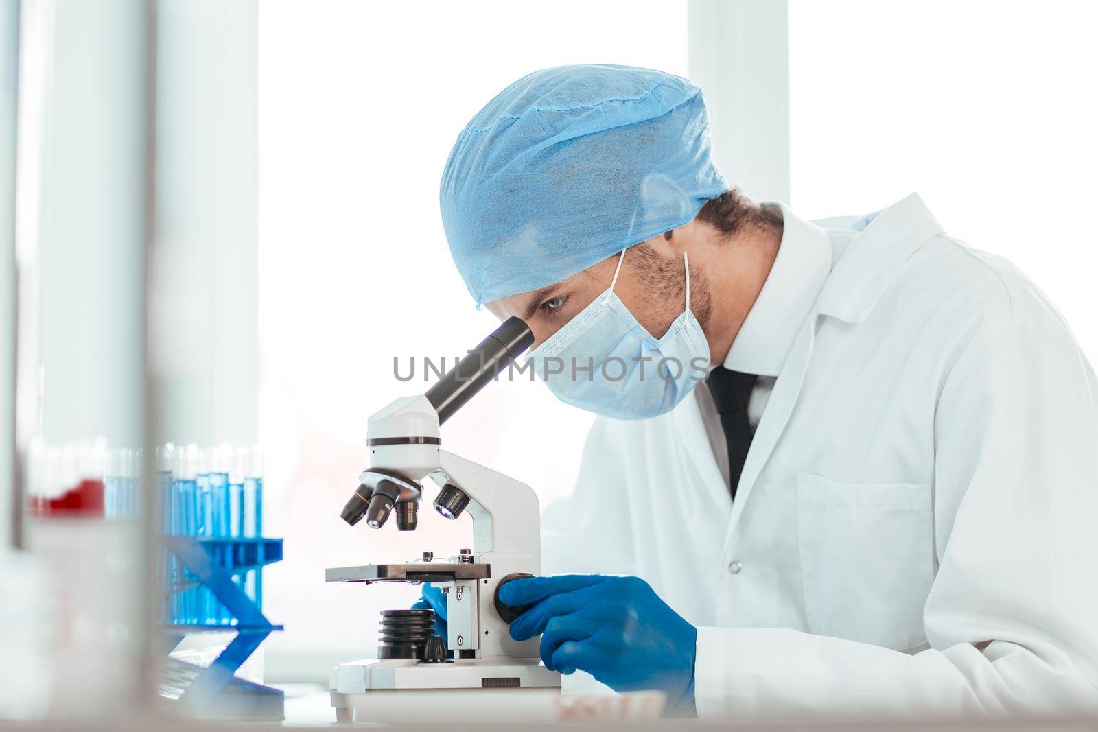 close up. scientist looking into the eyepiece of a microscope. photo with a copy-space.