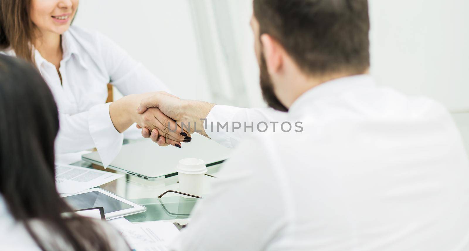 closeup of a handshake between the Manager and the client after the signing of the financial agreement in the workplace in the office