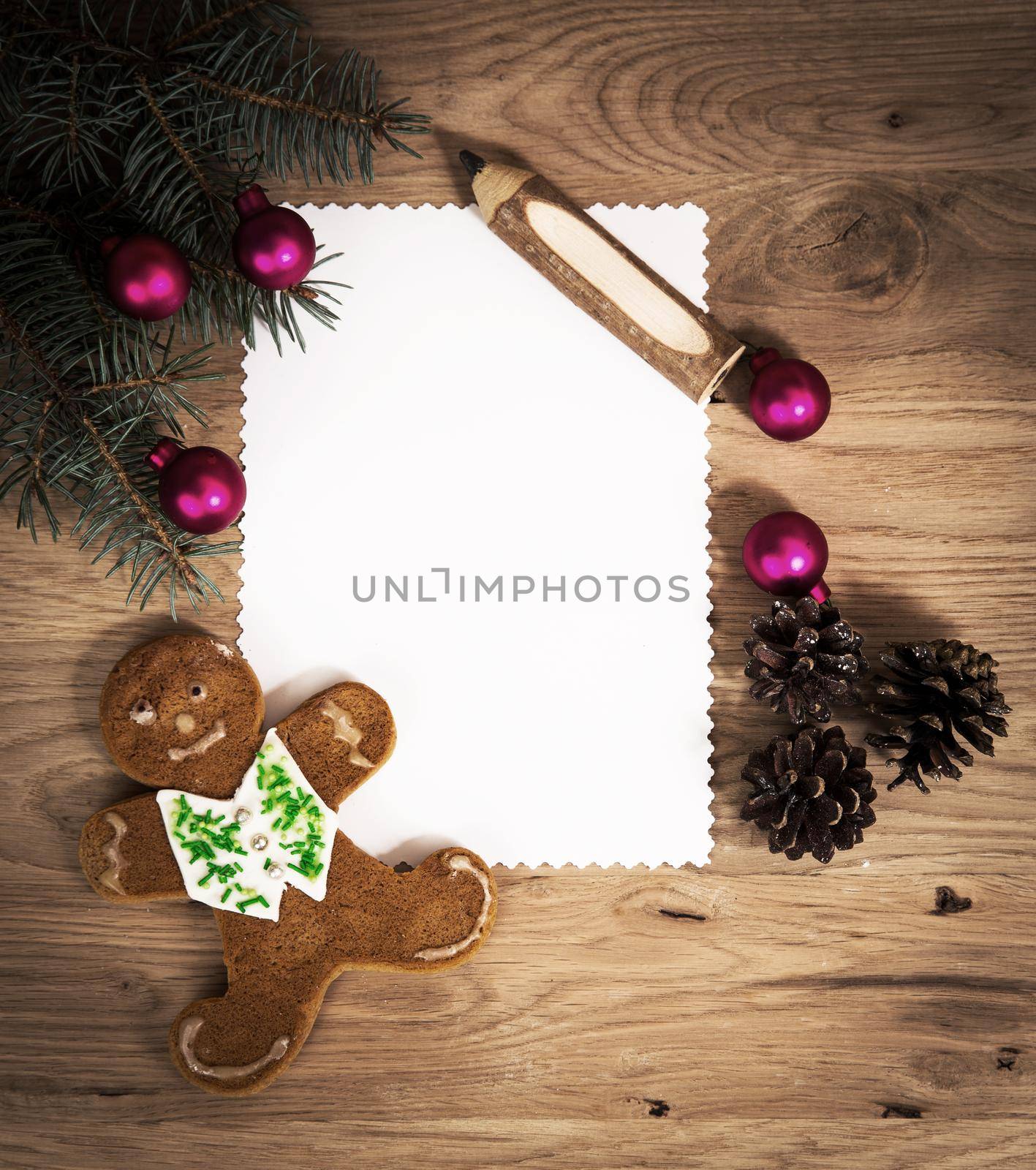 blank sheet of paper on the wooden floor with a pencil and Christmas decorations