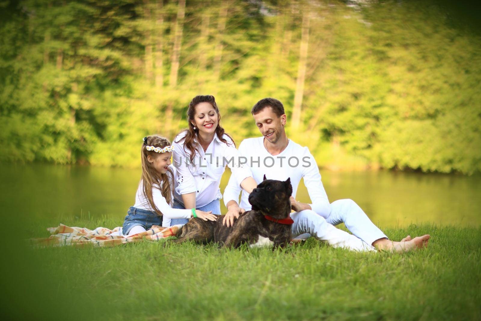 happy father of a daughter and a pregnant mom at a picnic. by SmartPhotoLab