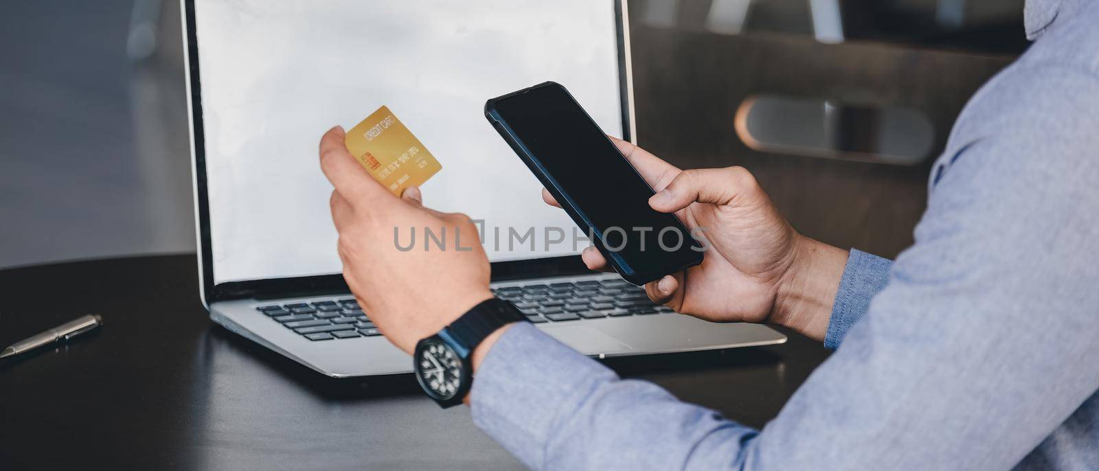 Online payment, Close up man's hands holding smartphone and using credit card for online shopping by nateemee