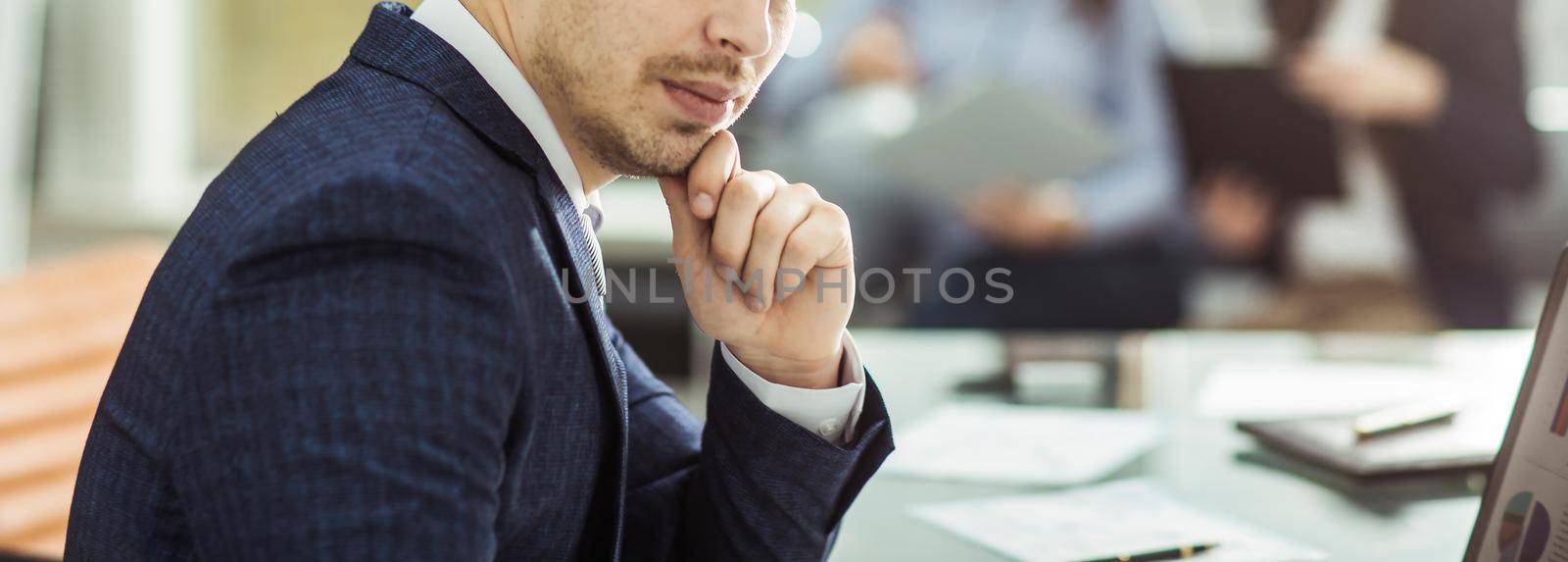 closeup of a senior Manager at the workplace on the background of business team