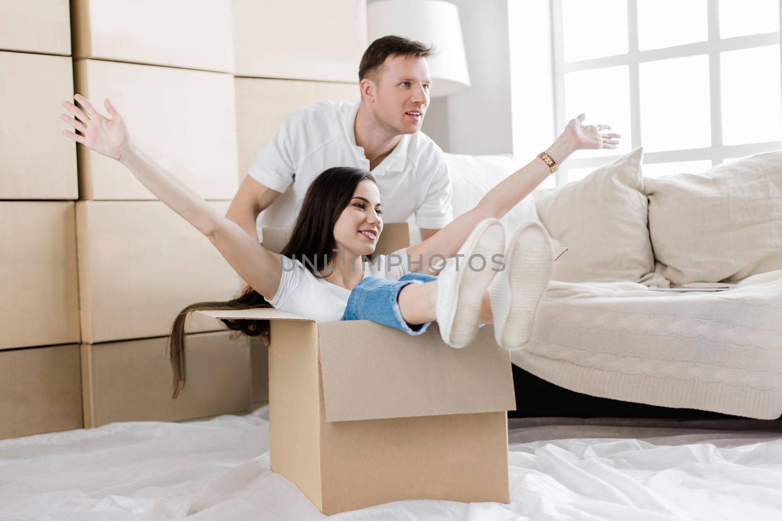 young couple having fun in their new apartment by SmartPhotoLab