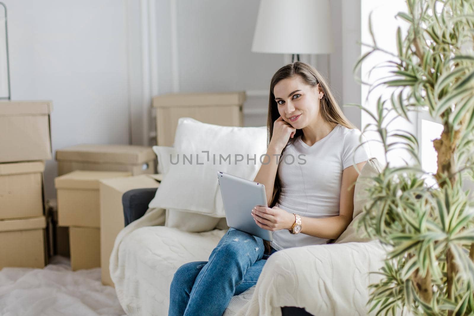 young woman with digital tablet sitting on a comfortable sofa. photo with copy-space