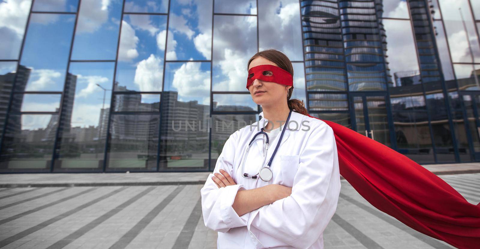 female paramedic in a superhero raincoat standing on a city street. photo with a copy-space.