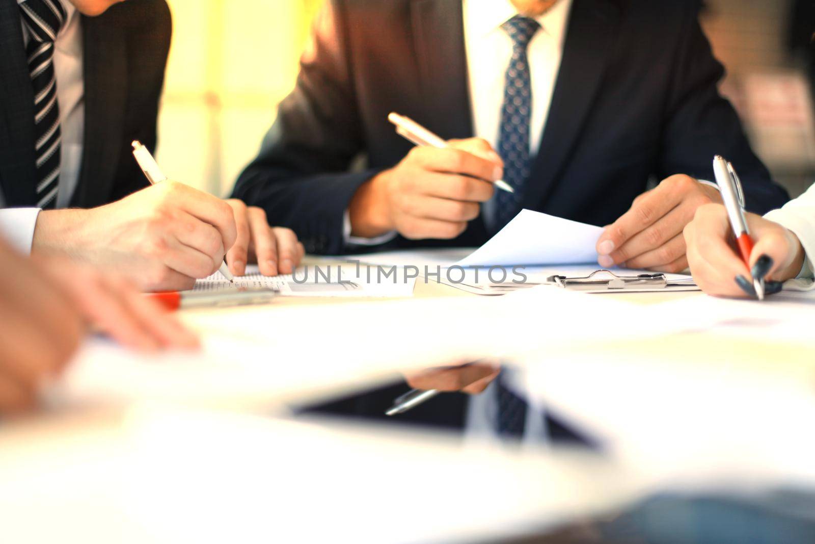 Businesswoman sitting in office, writing on documents.