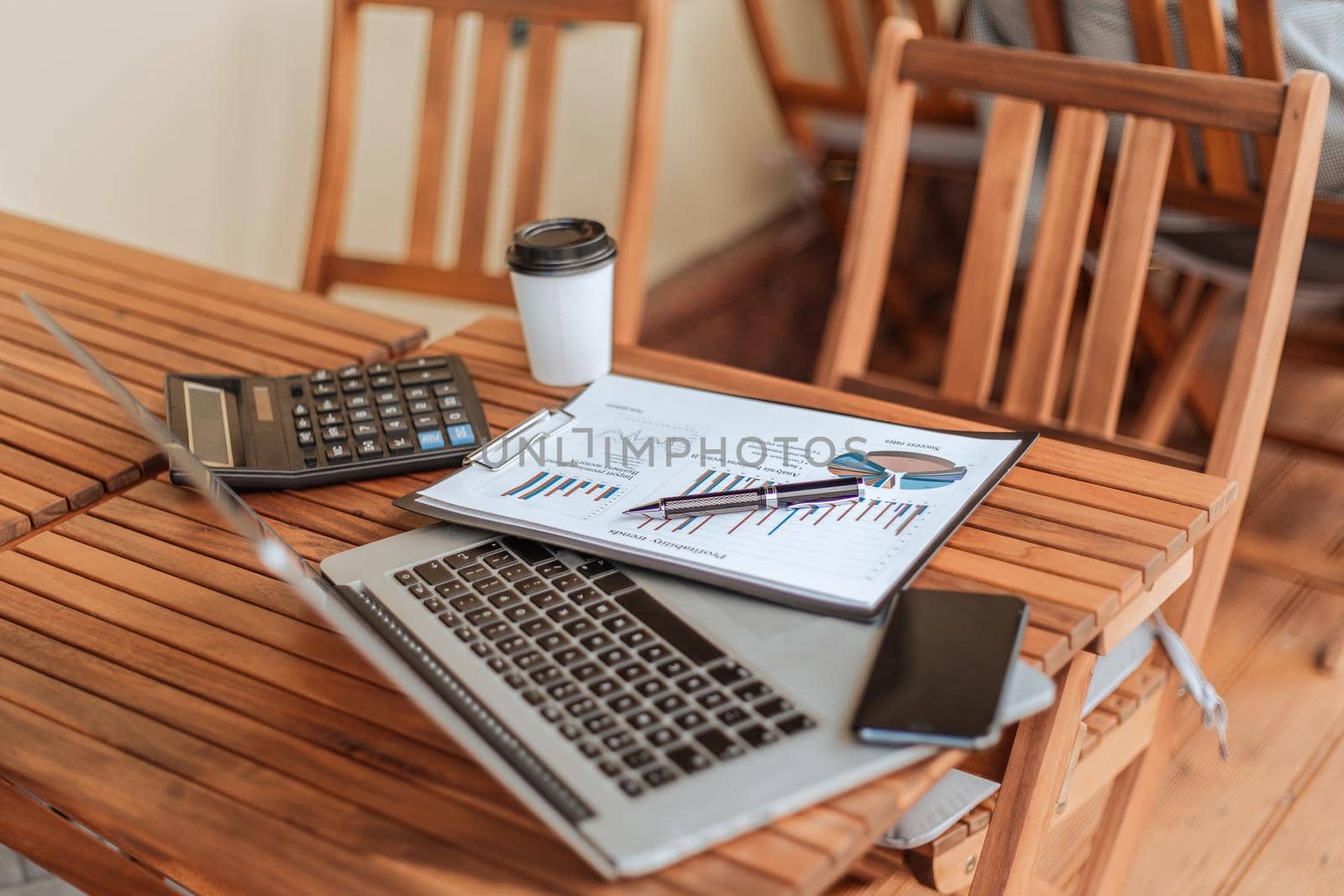 top view.takeaway coffee, financial chart, and laptop on coffee table. by SmartPhotoLab