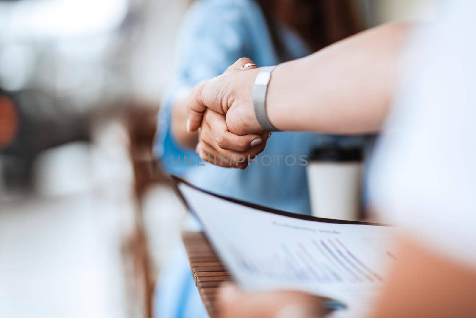 background image of a business handshake at an informal meeting. by SmartPhotoLab