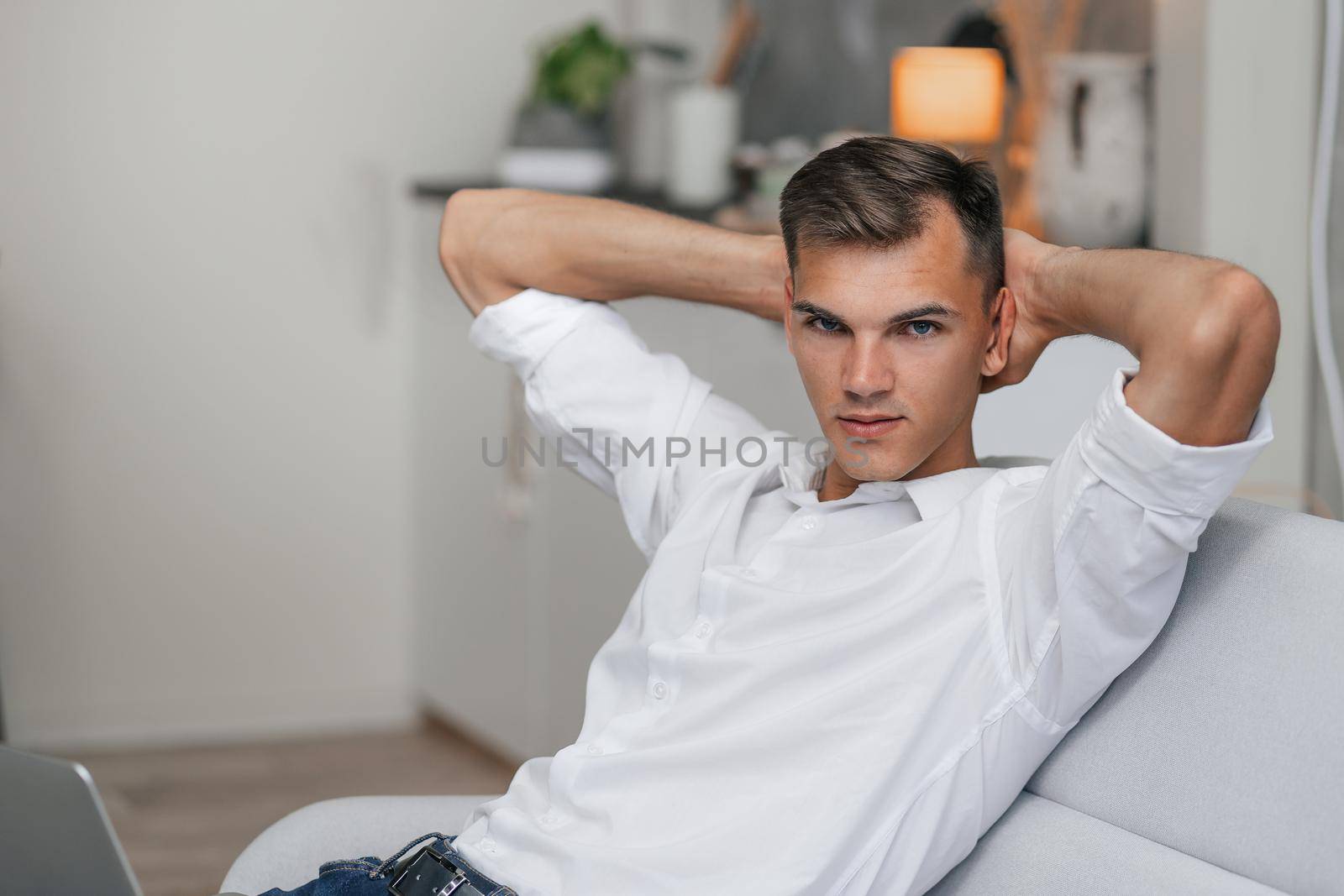 dreaming young man with a laptop sitting on the couch. by SmartPhotoLab